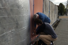 Mural being covered to protect it while laying concrete base for tiles