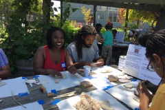 Community members make tiles to go at base of mural